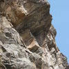 The route goes right through the center of the overhang. (Belay ledge hidden by a boulder.)