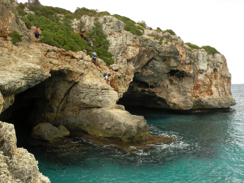 Climbers approaching the Metrosexual area.  The climbs are on the right-hand cave.  There is a convenient ledge between the two caves for storing gear and drying off between attempts.