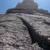 This is the penultimate pitch. The final pitch takes a hidden left-facing dihedral up and left through the overlaps.  Nice rock no?