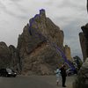 The Hitching Post (with The Fan behind it) taken from the Needles Eye parking lot.  The route follows the blue line from the right corner of the parking lot up and behind the Hitching Post then it climbs the last twelve feet up the steep left side of the summit on big (but very exposed) holds.