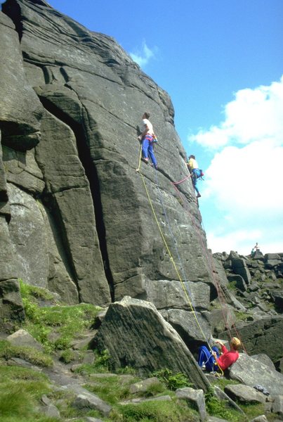 A climber commits to the crux on Pot Black.