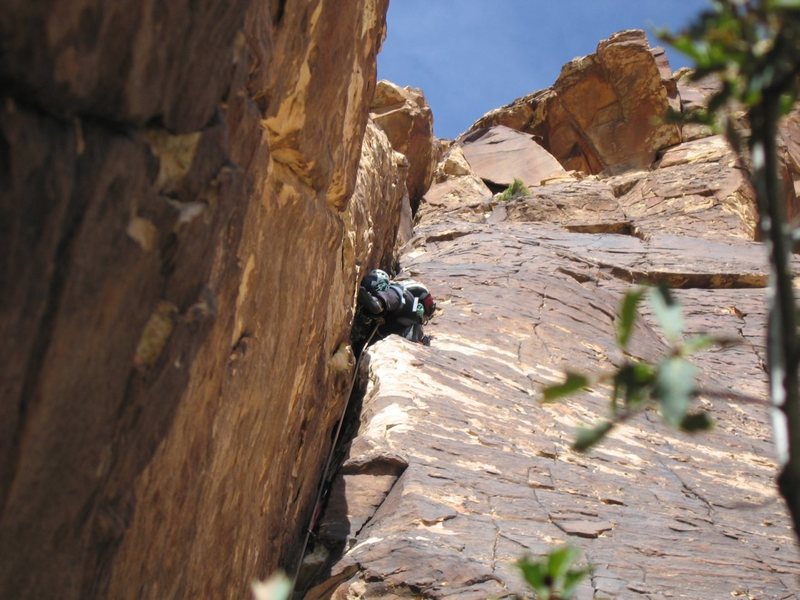 Having a fun time leading the wide crack/chimney pitch 2 of Jubilant Song in Windy Canyon, Red Rock.