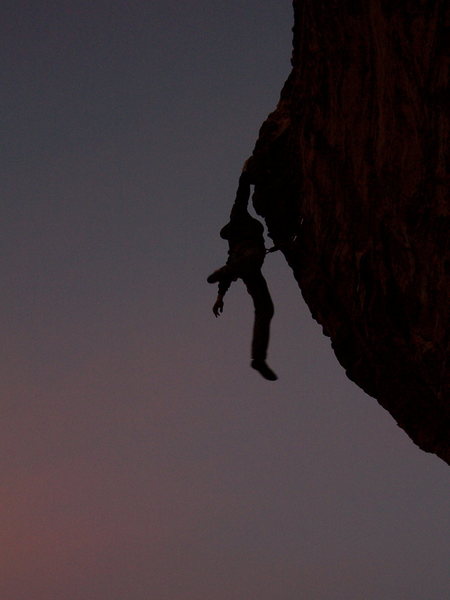 Veaz swinging from the final hold on a twilight send of Caustic.