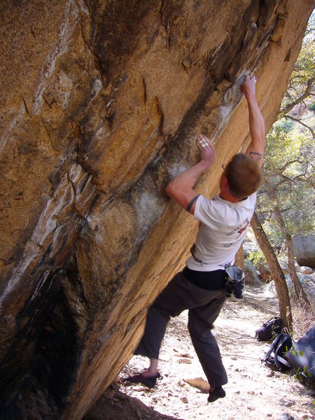 Campusing a crimp and pinch during the middle crux of the Fire-pit problem. 