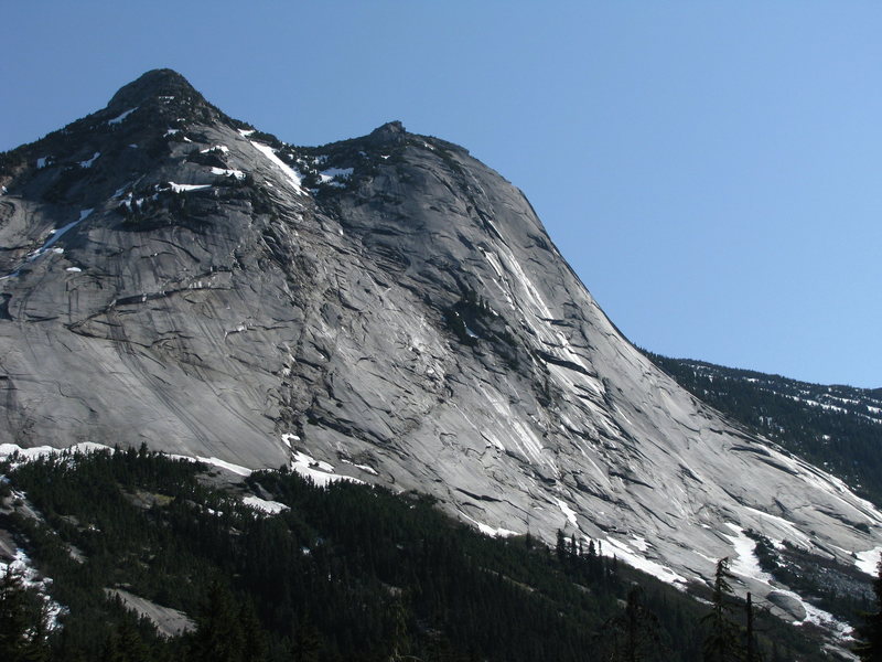 Yak Peak from the highway in late spring conditions, with melting snow and wet streaks.