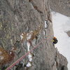 Jesse cleaning some gear on the upper flakes of Malander's Passage, after several late September snow squalls coated the wall quite nicely in white stuff and wet.