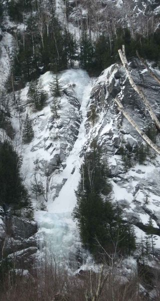 <em>Crystal Ice Tower</em> at the bottom. <em>White Line Fever</em> is its continuation, running up the snow chute through a narrow ice band, with yet another pitch above the belt of trees.