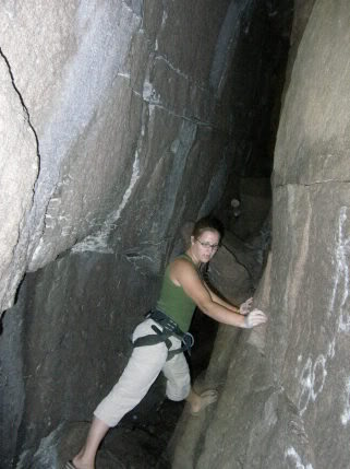 Meg at the start of the "Devils Den" cave.  From here the fissure goes back horizontally for 30-40 feet, then escape is made by ascending a 14' +/- ladder.  One can also exit by continuing left at the ladder, chimneying up towards daylight, and then popping out of a smallish hole atop a sizable drop off.<br>
<br>
Headlamp or flashlight recommended for your first time exploring the cave.