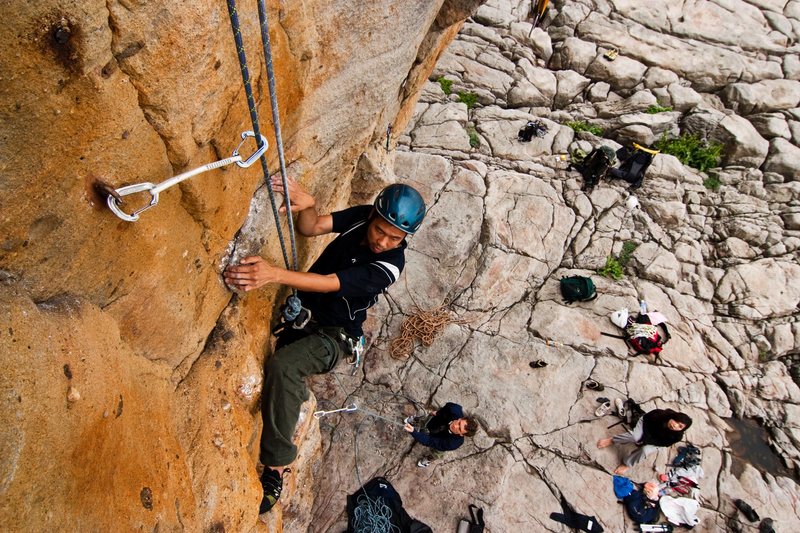 A climber cleaning the Middle Route above the crowd in Music Hall.