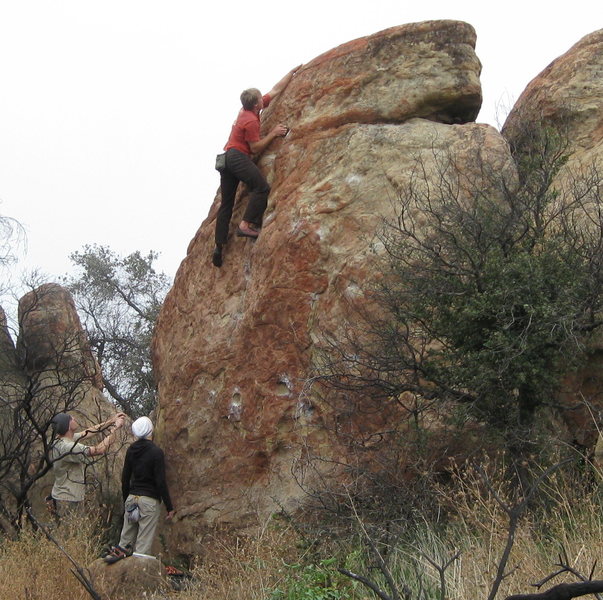 The Extremist boulder.  The climber is topping out the Extremist, and the Moderate goes up just to the right of it.