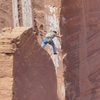 Nico leading pitch 3; about to step across onto the arete