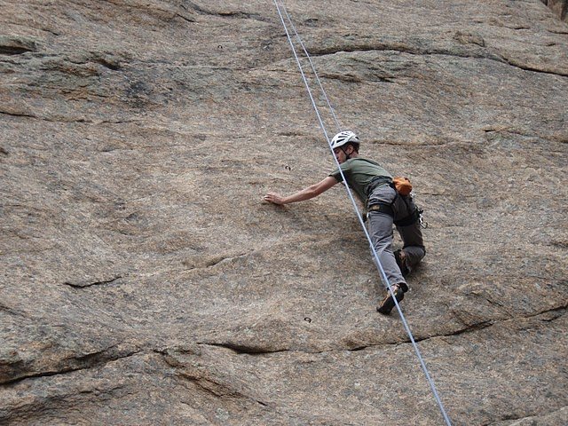 Darren Buford tries to find hands on the slabby rock of Triceratops. 