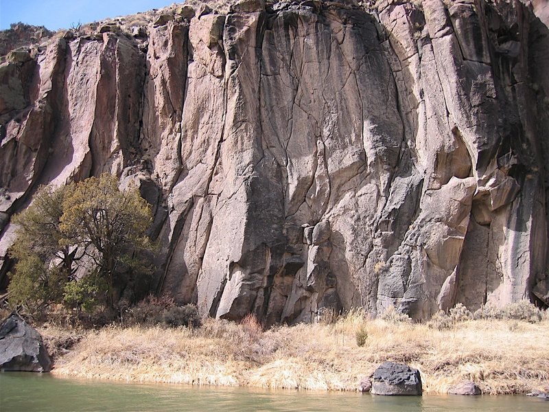 Curving handcrack at right center of pic in gray rock. Directly above rock at river edge.in this photo.