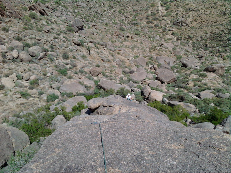 Ann seconding past the crux on pitch one, near the anchors.