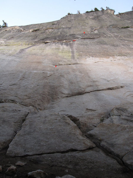 I have added two red bolts marking the first belay and two small red 'g' symbols on this photo to show where the two pieces of gear listed in the description are on the first two pitches. If you look around a bit, you should be able to figure out the rest.