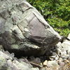 Large boulder found half way up the slant boulder field and west into the woods.  This is below the Hangman Towers, see Climbers Guide.