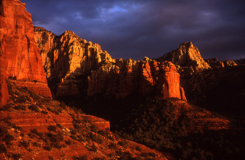 King Crimson (right of center) catches another spectacular Sedona sunset. The Southwest Face Rt climbs left of center in the sunlit face.