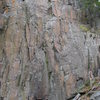 Cliff drifts upwards with unbolted rock face.Good 5.10 route potential past the "camp fire" stained rock.