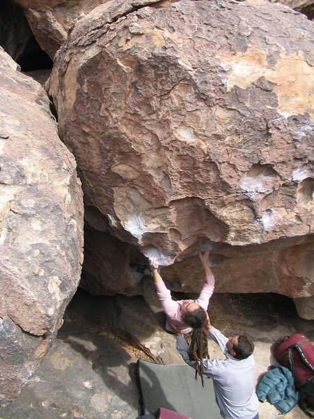 Unknown climber squeezing between a terrible sloper and pinch while fighting to keep her foot on the slick starting hold.