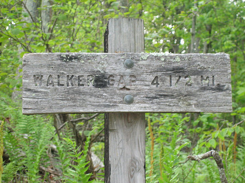 After you park. Walk straight ahead to this sign and the trail will walk over the top rim of the cliffs. walk to the opposite side of the road from the parking and you will find bouldering.