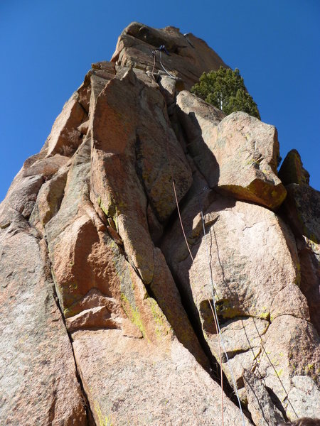 The route with a climber just below and to the left of the crux roof moves.