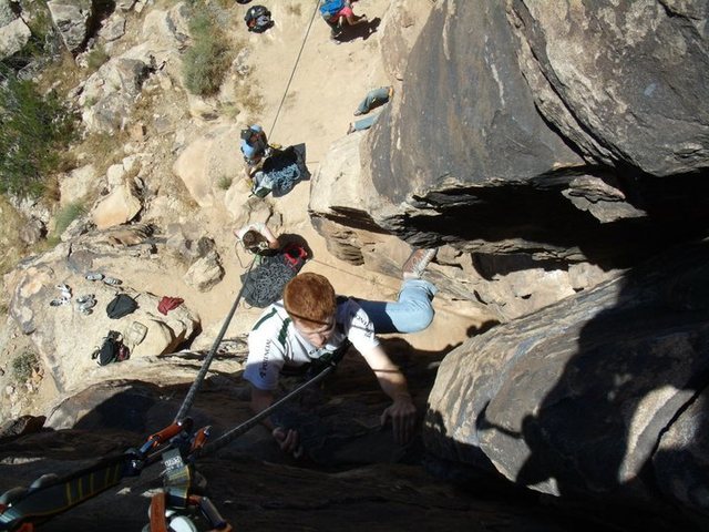 View from the top.  Eric about to top the route, with view of belaying area underneath him.