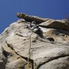 Installing the protection bolt on the first ascent of Just Face It.