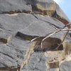 A close-up of the crux roof and upper slab finger crack of pitch three.