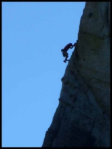 Unknown climber clearing the classic arete on the third pitch. 