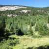 The view of Nathan's Wall from the parking lot.   A climber is visible walking down the trail.