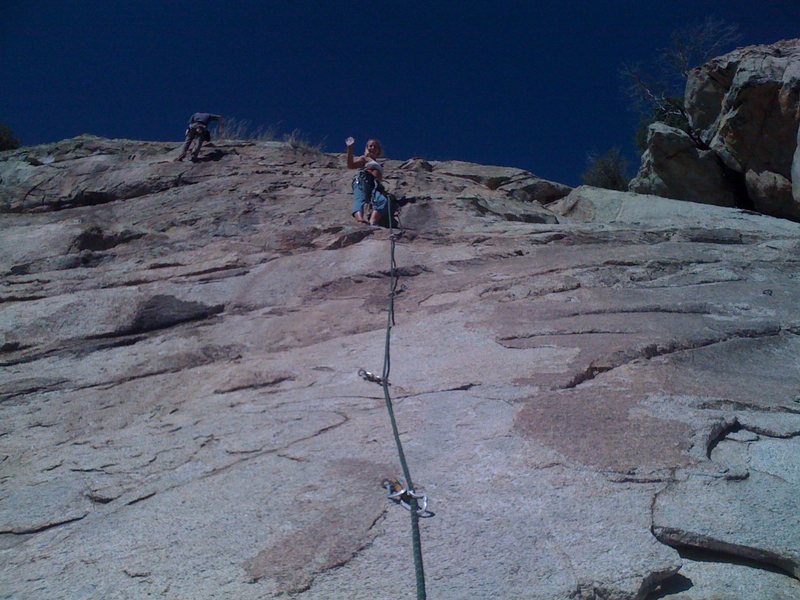 Kristina leading "Out Of The Ashes" and waving for the camera at a ledge 2/3 of the way up. We then climbed this useing only the first 2 bolts and then gear.