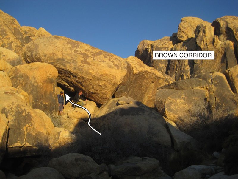 If you go to this cave entrance on the south end of the corridor you can scoot up an easy slab then head right through a tunnel, boulder hop and you're right under Mojave Green Arete.