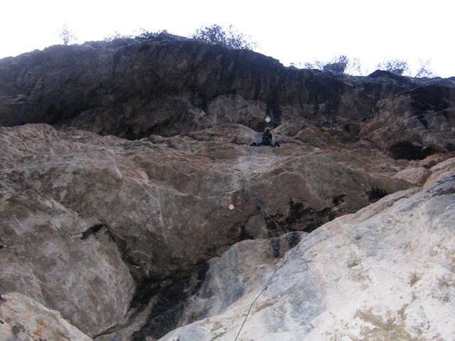 Steep rock under overhangs:  climbing in the rain at Landro