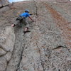 Joe steps off the pillar into the seam on the first ascent of Grape Nuts.