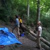 At the bottom of the blue route is some logs and rocks to sit on.  Belayer needs to watch footing carefully.