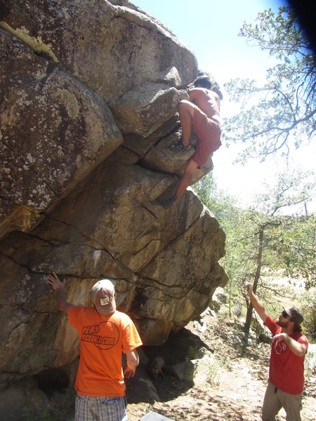 Going for the top out on the V1 problem in the center of the boulder