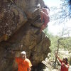 Going for the top out on the V1 problem in the center of the boulder