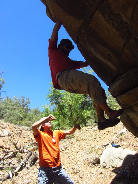 Luke Bollinger on the starting moves of the overhanging problem in the center of the boulder.