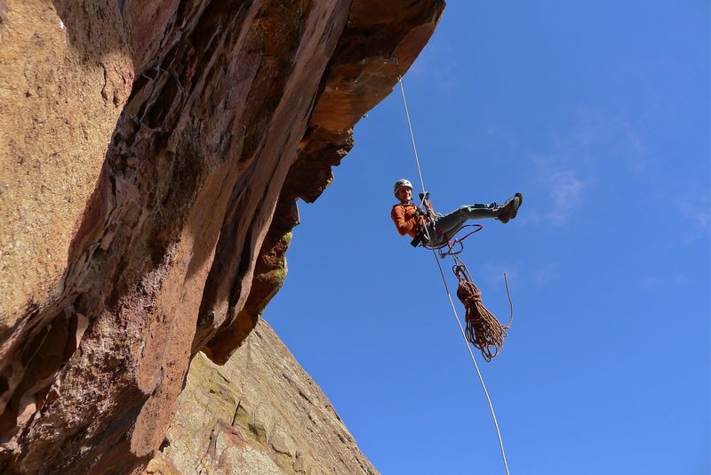 Heather Weidner rapping over the crux roof for another work session on the 13c pitch.