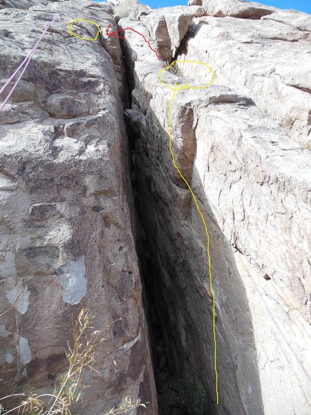 Chimney up with your back where the yellow line is. Pull onto the ledge on the right side and jump left over the crack to the slab column. (bolted)