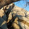 It is the crack to the right of the larger chimney starting right on top of the boulders, belay from the top of the boulders.