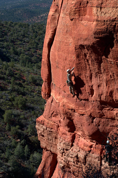 Mike reaching the crack. Hugo belaying on the exposed limestone perch.