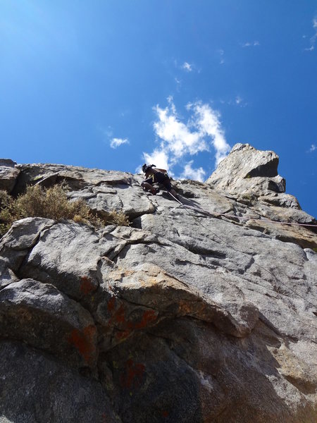 traverse right from here to get the crux, or go straight over the arete for a 5.9 variation. The anchor is up and to right of the climber