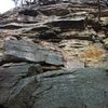 I went straight up the slab beneath the vertical fractures (on the right under the orange roof). Traverse left and up over the roof, move right up to the pin, straight over the roof from there.