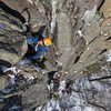 Cysty Ugler: A climber moves onto the ledge at two-thirds height.