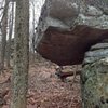 "Legion" (V7) stand starts under the roof on the low block and climbs directly out, topping out straight over the upper block.