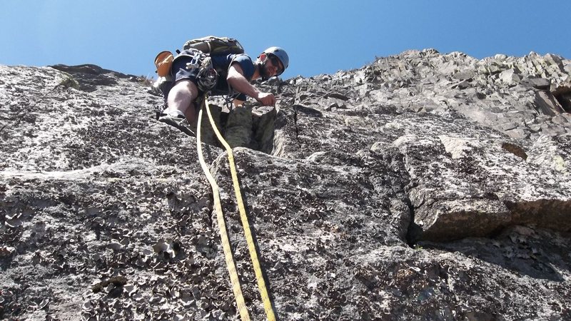 Mike putting gear after the twelve foot very lichen covered crux. 