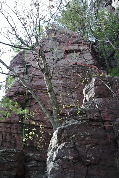 The route "Innocence" marked in green line and "Crimps and Misdemeanors" marked in red.  The starting moves are obscured by little buttress in the foreground in the this photo and are where the dashed red line is.  