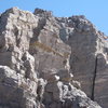 The Direct South Ridge climbs through this exposed section of easy 5th class. Someone has placed a fixed rope here to aid in ascent/descent. As seen in this photo, the wind can render it useless.