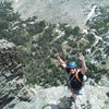 Travis Parigi near the top of P2, psyched to be climbing new terrain up high on a cool feature. Top of the Main Buttress below, some loose rock on the ledge at Travis' feet.